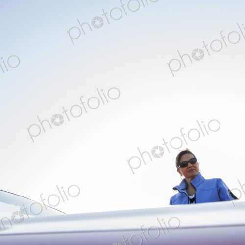 A portrait of a hip senior Hispanic woman on a road trip with her husband.