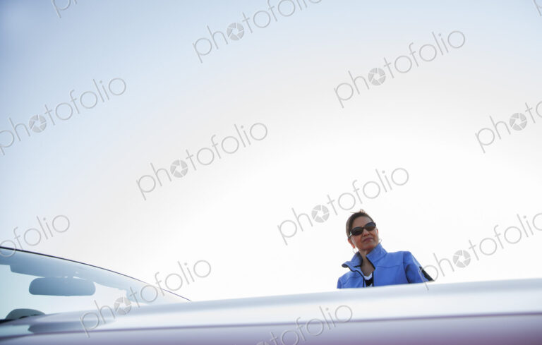 A portrait of a hip senior Hispanic woman on a road trip with her husband.