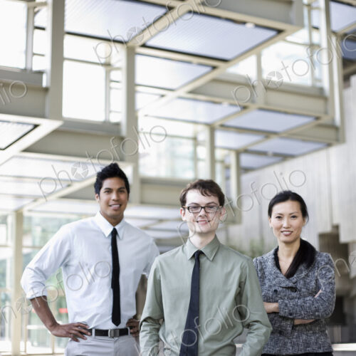 A portrait of a mixed race team of business people standing in the lobby area of a… A portrait of a mixed race team of business people standing in the lobby area of a…