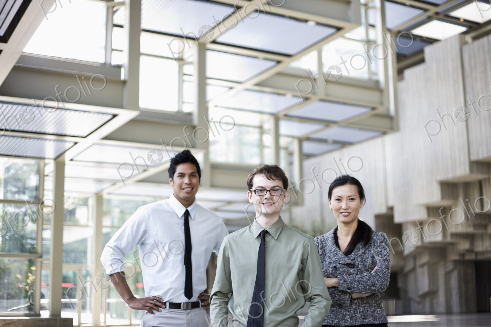 A portrait of a mixed race team of business people standing in the lobby area of a…