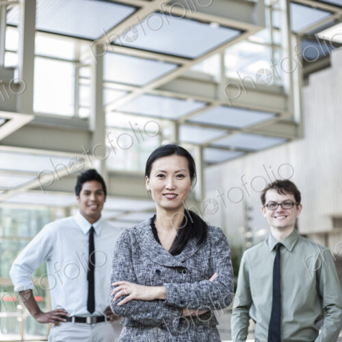 A portrait of a mixed race team of business people standing in the lobby area of a… A portrait of a mixed race team of business people standing in the lobby area of a…