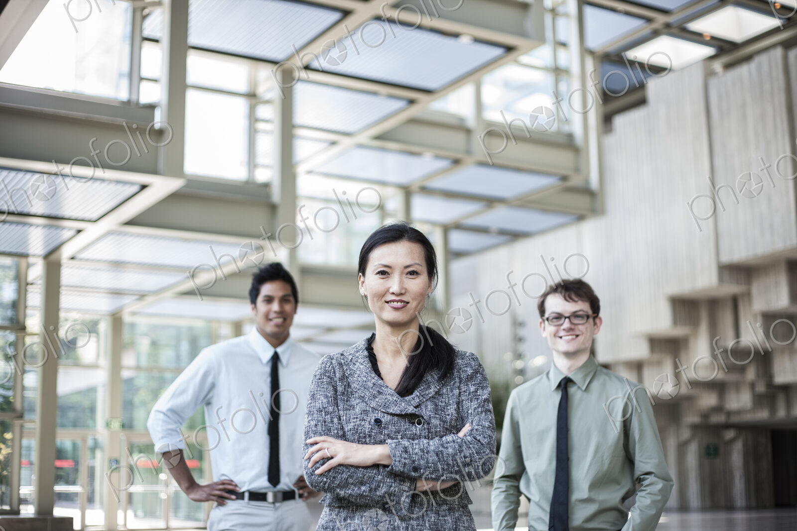 A portrait of a mixed race team of business people standing in the lobby area of a…