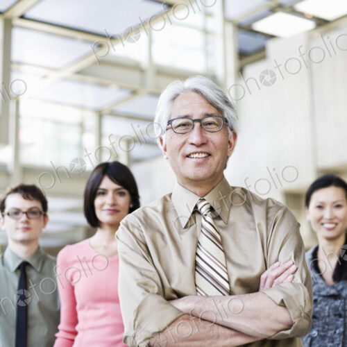 A portrait of a mixed race team of business people with an Asian businessman in the lead. A portrait of a mixed race team of business people with an Asian businessman in the lead.