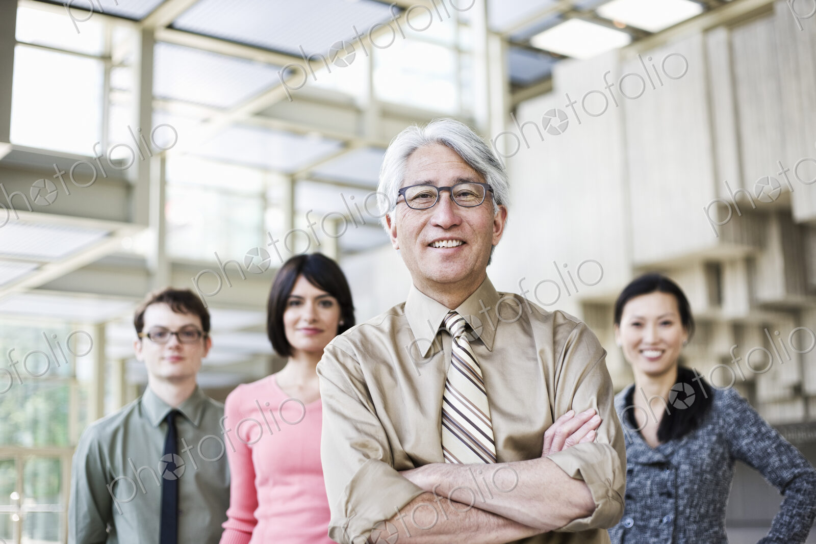 A portrait of a mixed race team of business people with an Asian businessman in the lead.