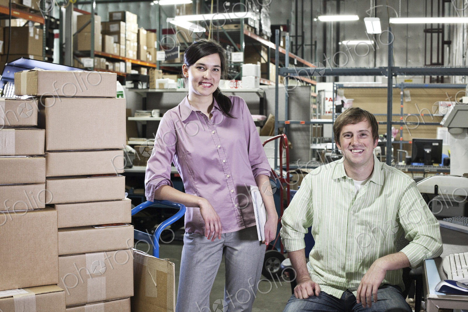 A portrait of a team of two caucasian male and female workers in a parts department…