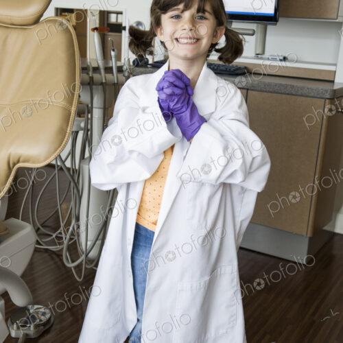 A portrait of a young Caucasian girl playing dress up in a dental office. A portrait of a young Caucasian girl playing dress up in a dental office.