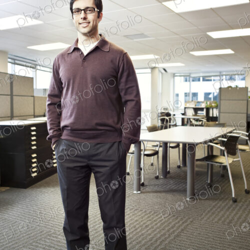 A portrait of a young Hispanic businessman standing in his office. A portrait of a young Hispanic businessman standing in his office.