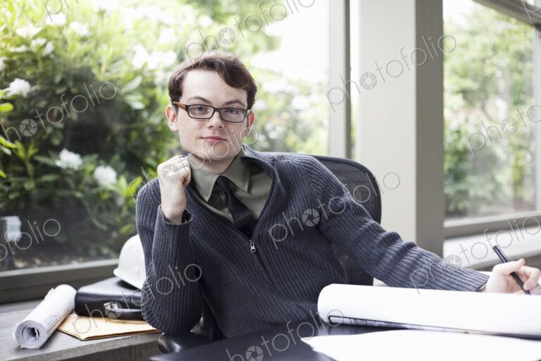 A portrait of a young hip businessman sitting in his office.