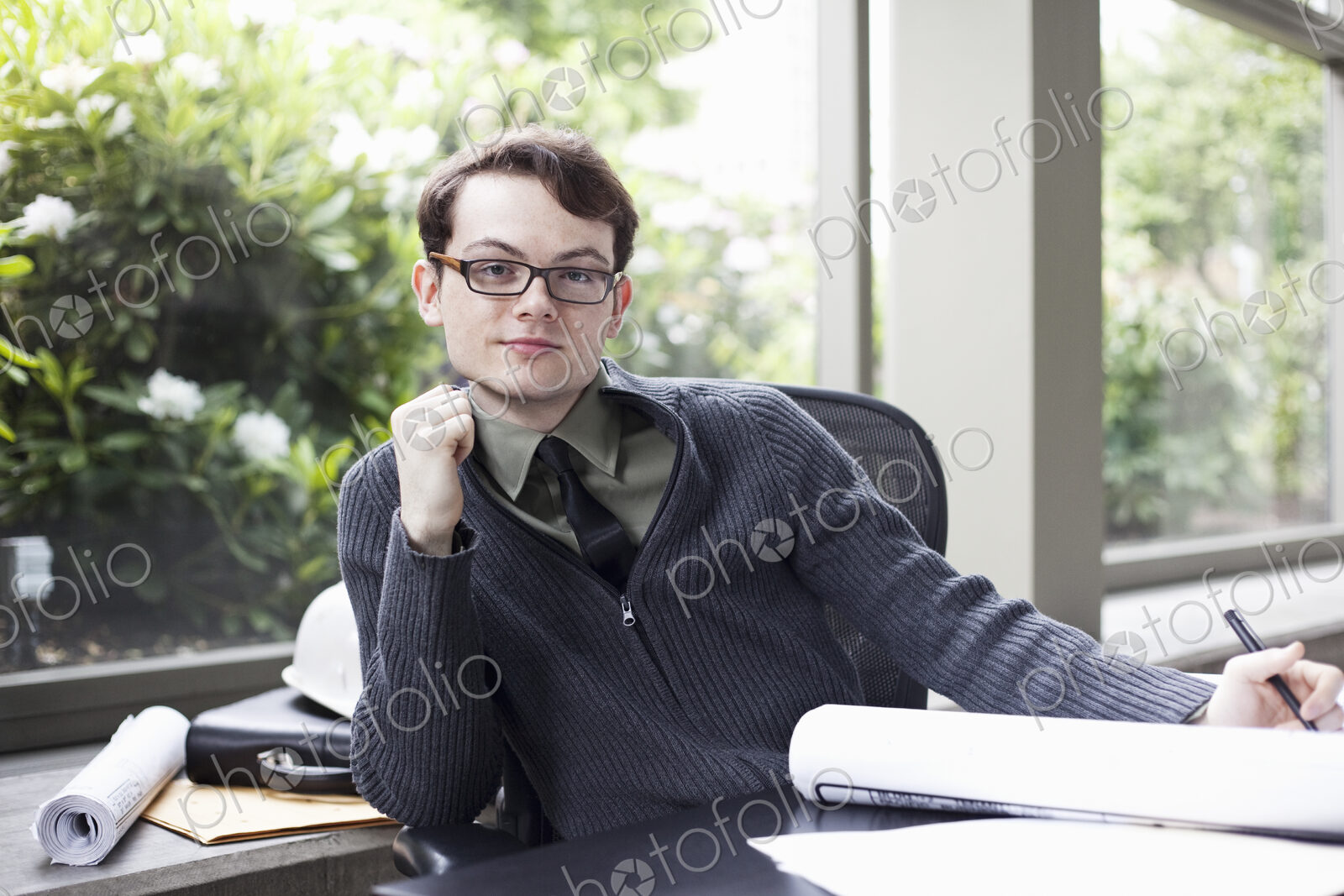 A portrait of a young hip businessman sitting in his office.