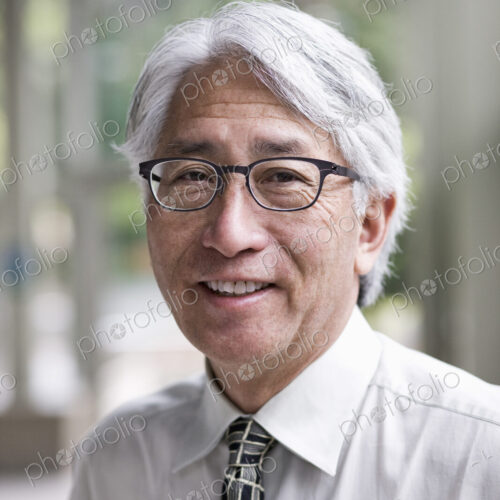 A portrait of an Asian businessman in a convention center setting. A portrait of an Asian businessman in a convention center setting.