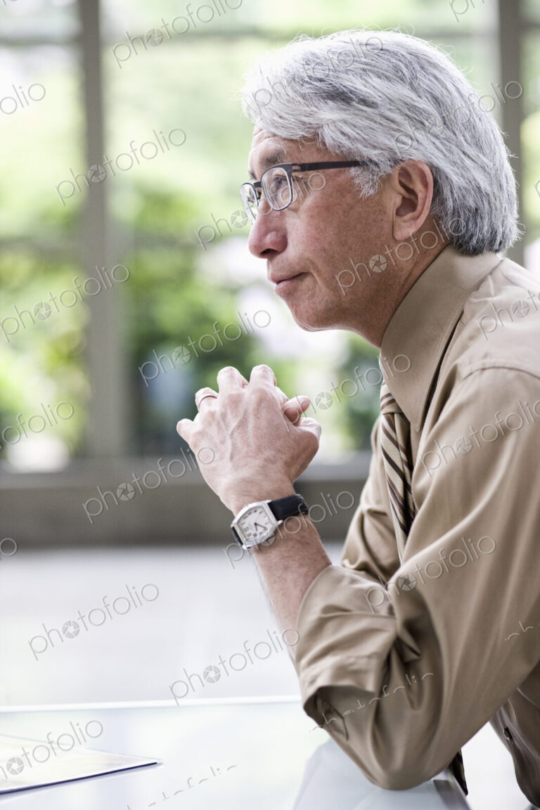 A portrait of an Asian businessman in a convention center setting.