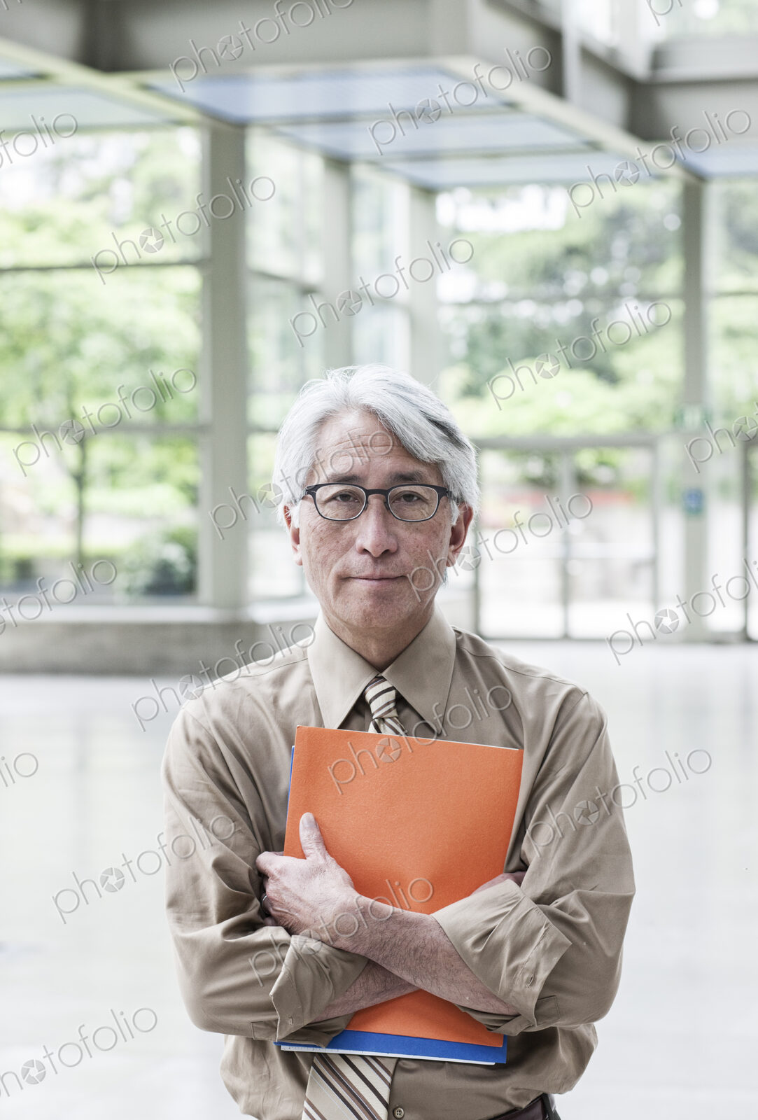 A portrait of an Asian businessman in a convention center setting.