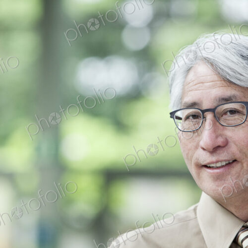 A portrait of an Asian businessman in a convention center setting. A portrait of an Asian businessman in a convention center setting.