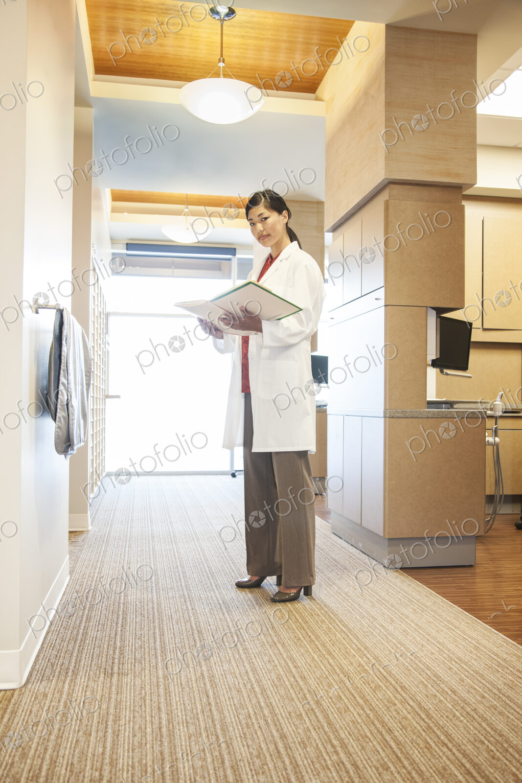 A portrait of an Asian female dentist in her office.