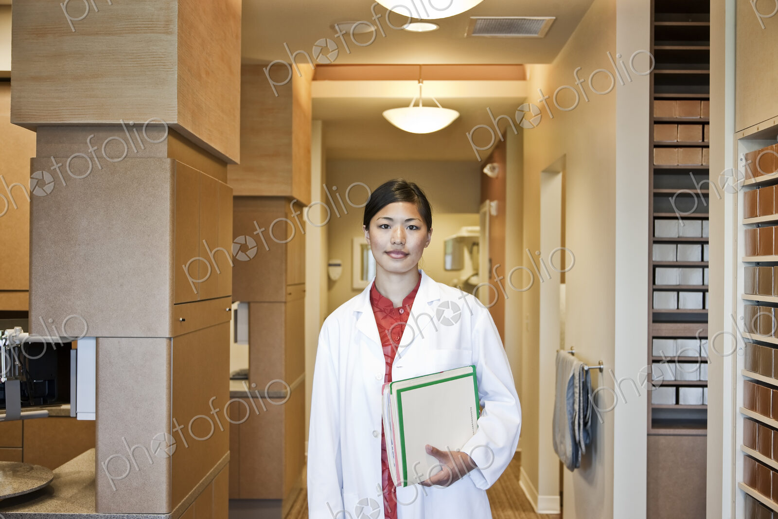 A portrait of an Asian female dentist in her office.