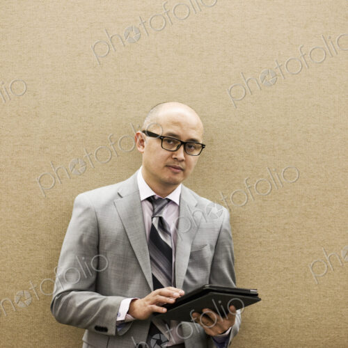 A portrait of an asian businessman holding a notebook computer. A portrait of an asian businessman holding a notebook computer.
