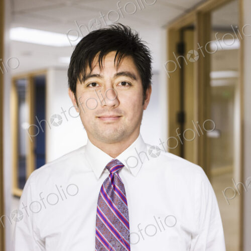 A portrait of an asian businessman standing alone in his office space. A portrait of an asian businessman standing alone in his office space.