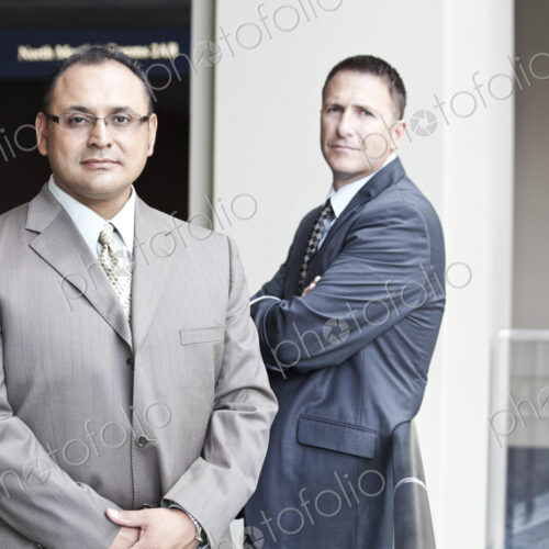 A portrait of an hispanic businessman and a caucasian businessman in a convention…
