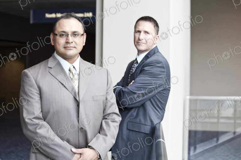 A portrait of an hispanic businessman and a caucasian businessman in a convention…