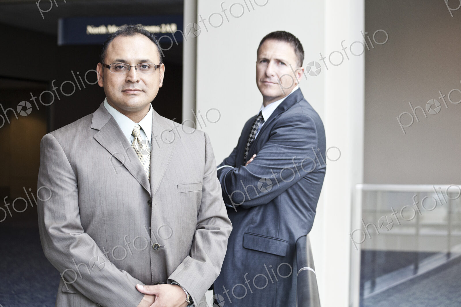 A portrait of an hispanic businessman and a caucasian businessman in a convention…