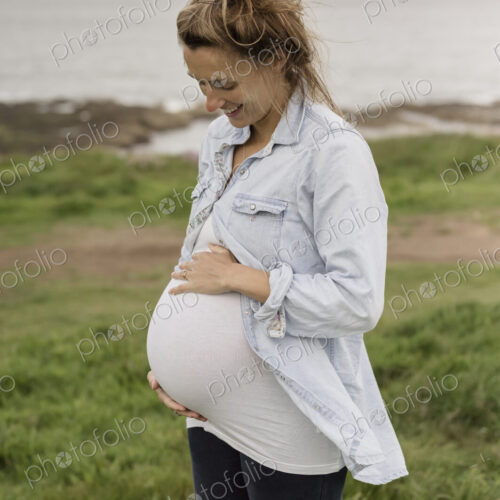 A pregnant woman on a coastal path.