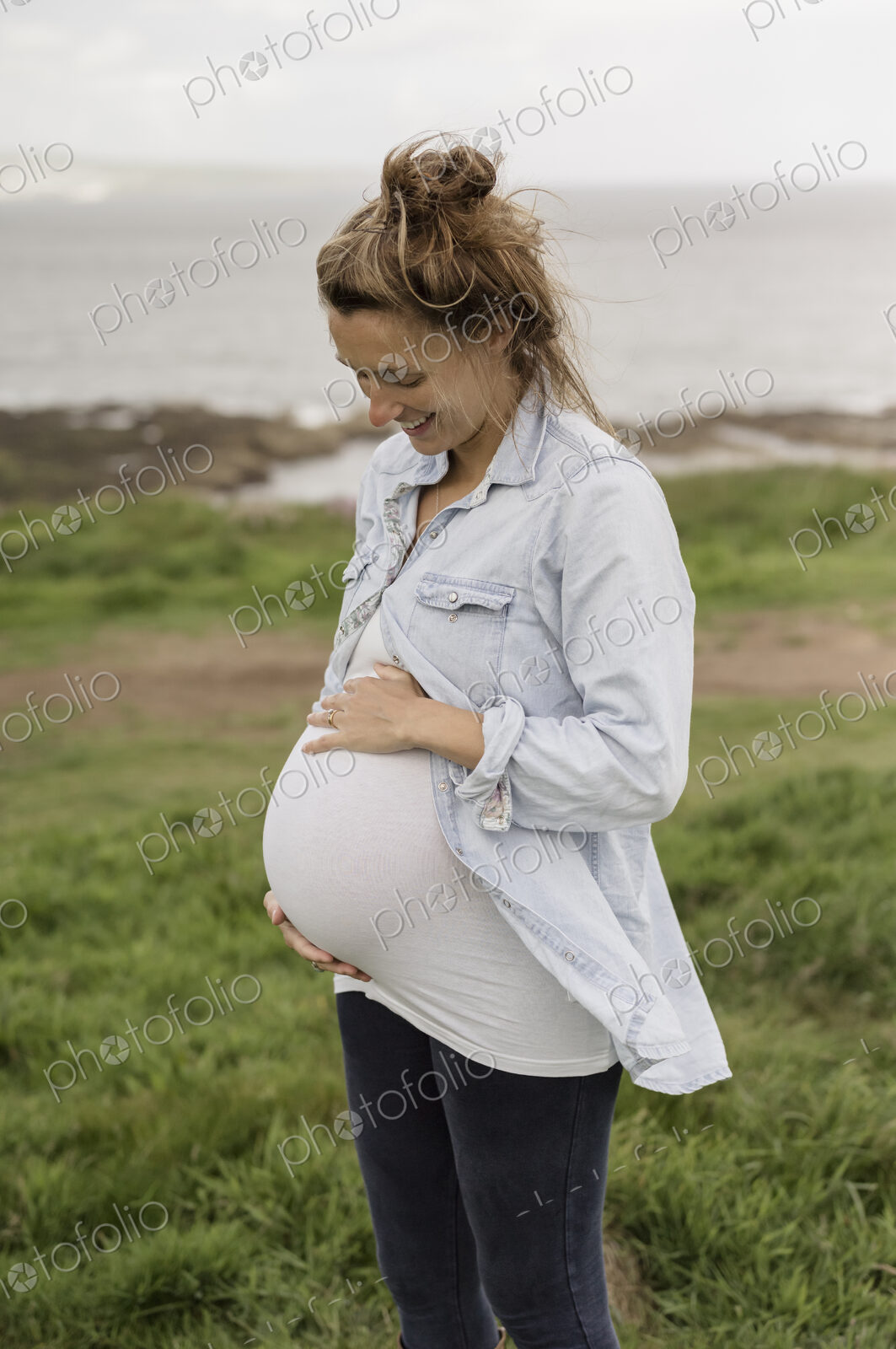A pregnant woman on a coastal path.