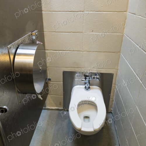A public restroom cubicle, a toilet at a reststop on a major road. A public restroom cubicle, a toilet at a reststop on a major road.