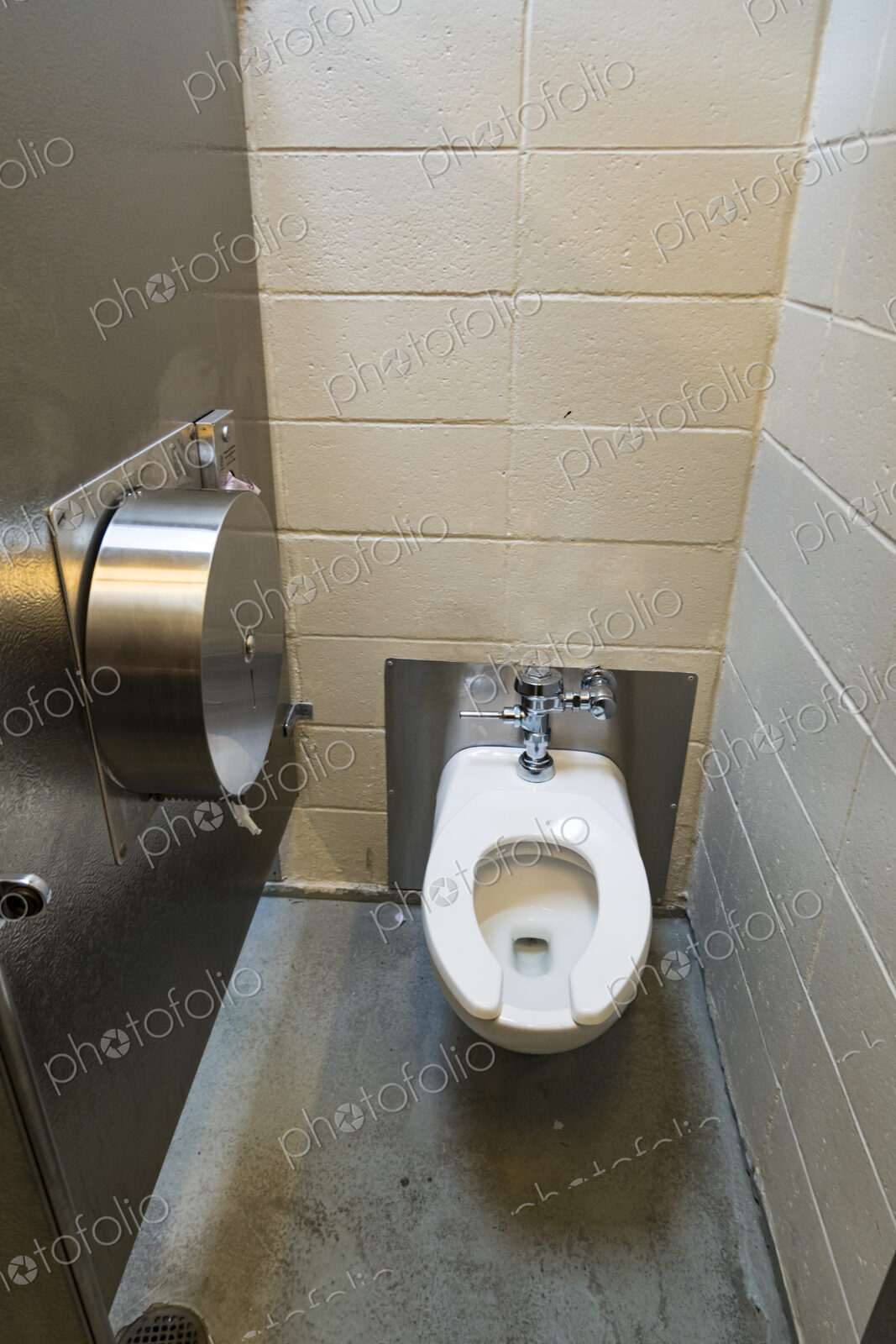 A public restroom cubicle, a toilet at a reststop on a major road.