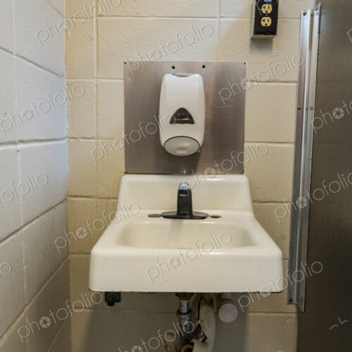 A public restroom toilet at a reststop on a major road, a washbasin for handwashing. A public restroom toilet at a reststop on a major road, a washbasin for handwashing.