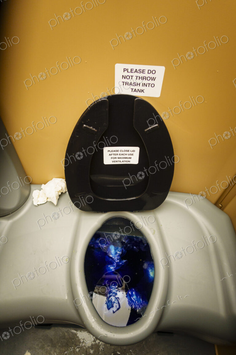 A public restroom toilet cubicle, a toilet at a reststop on a major road.