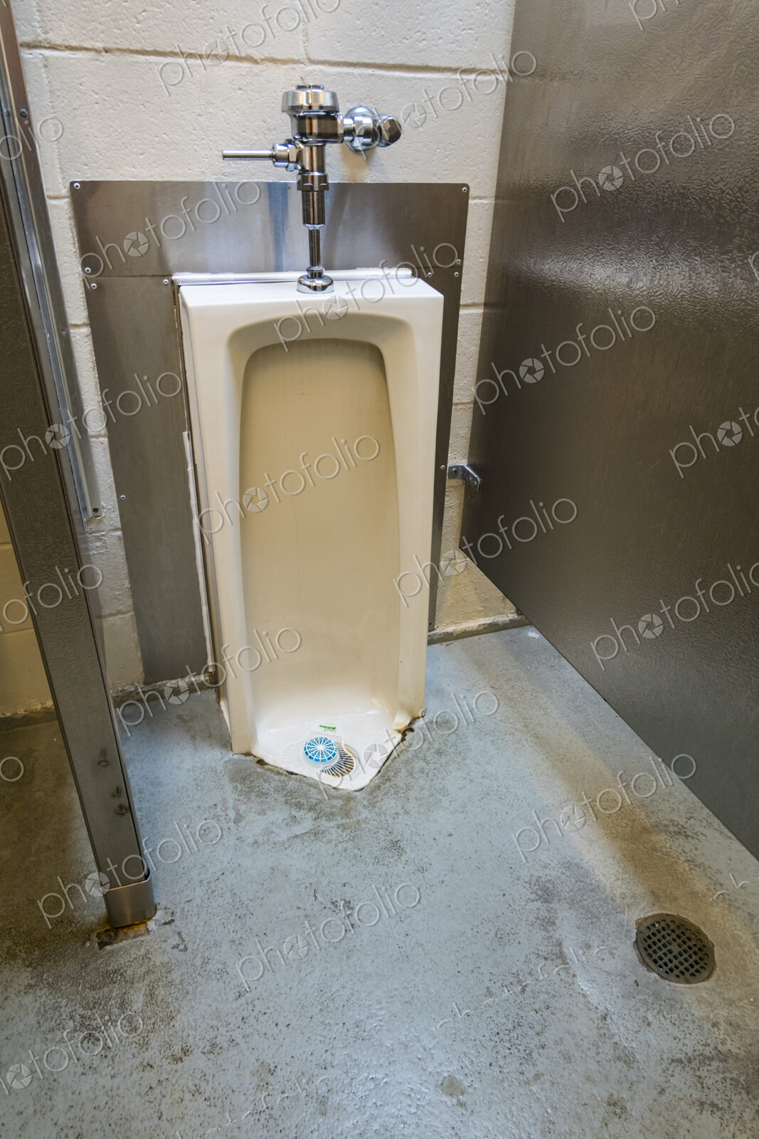 A public restroom urinal, a toilet at a reststop on a major road.