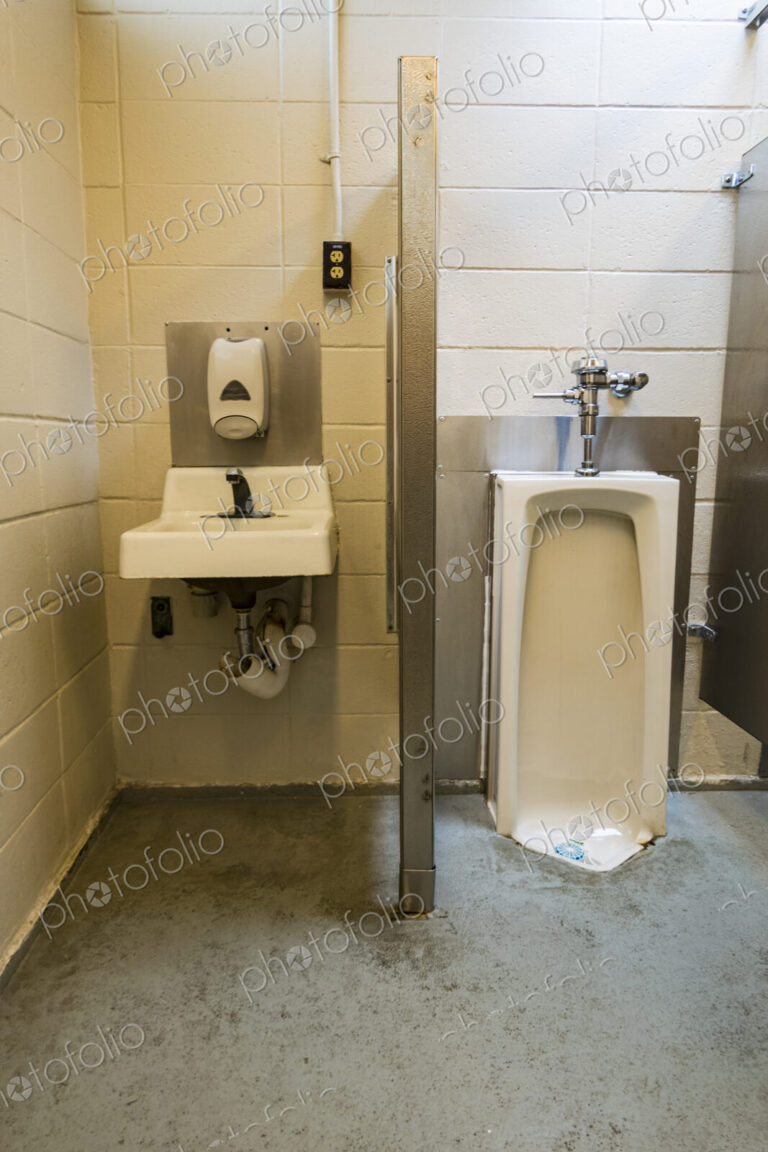 A public restroom urinal, a toilet at a reststop on a major road.