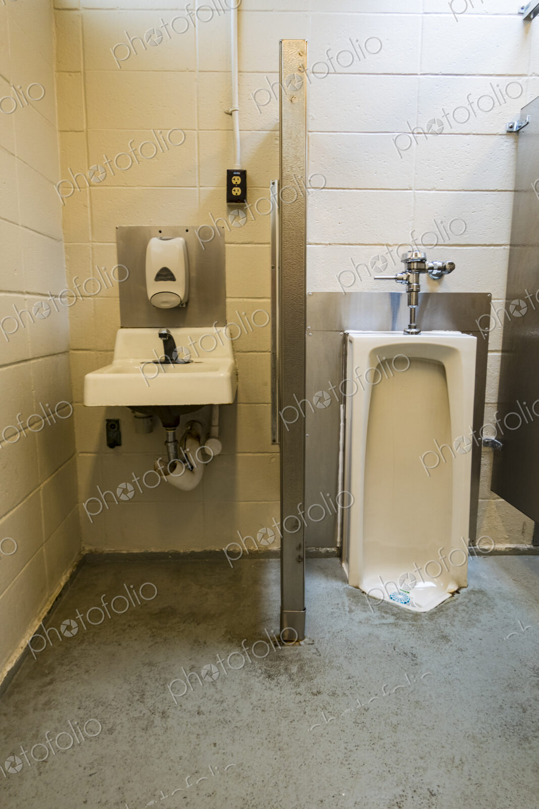 A public restroom urinal, a toilet at a reststop on a major road.