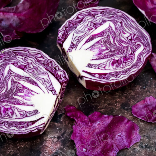 A raw round red cabbage, cut across the middle. A raw round red cabbage, cut across the middle.