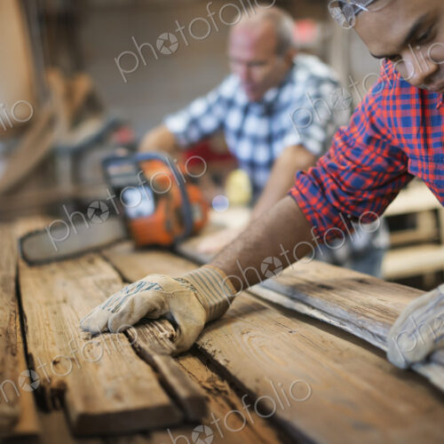 A reclaimed lumber workshop. A group of people working. A man measuring and checking… A reclaimed lumber workshop. A group of people working. A man measuring and checking…