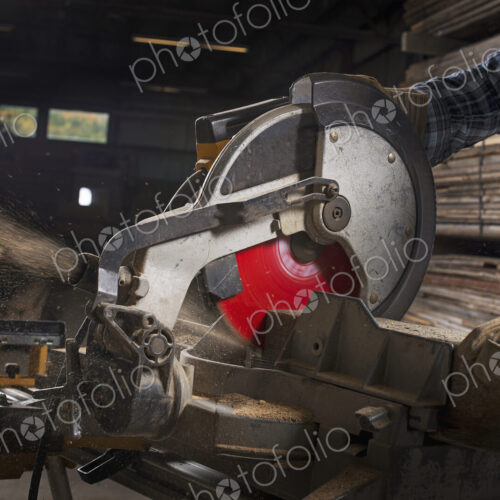 A reclaimed lumber workshop. A man in protective eye goggles using a circular saw to… A reclaimed lumber workshop. A man in protective eye goggles using a circular saw to…