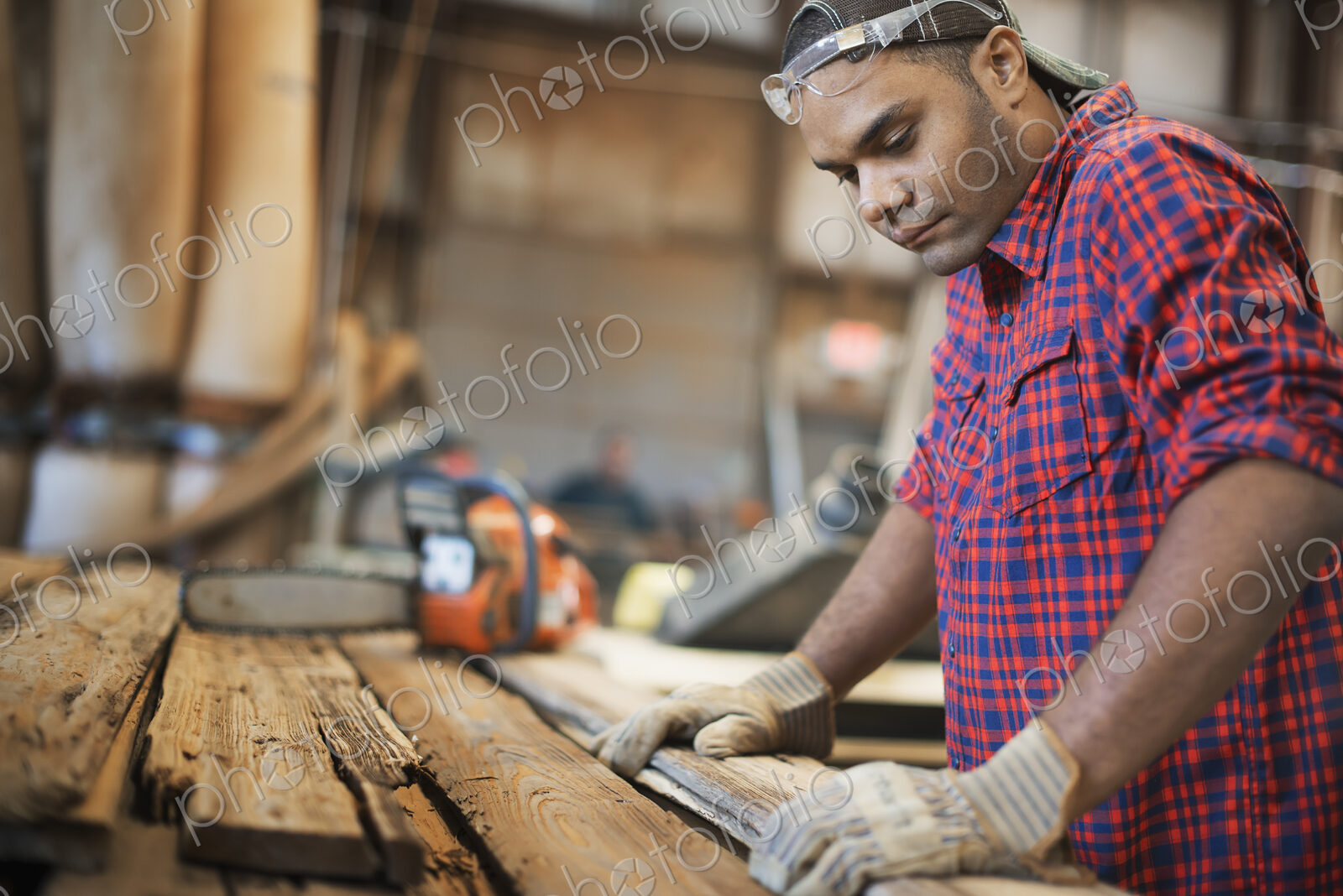 A reclaimed lumber workshop. A man measuring and checking planks of wood for re-use…