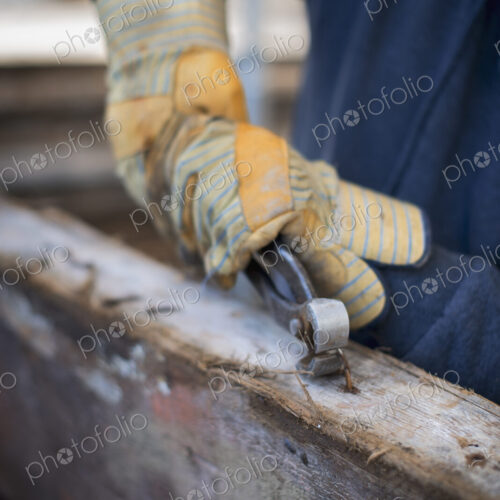 A reclaimed lumber workshop. A man preparing the timber by removing all the nails and… A reclaimed lumber workshop. A man preparing the timber by removing all the nails and…
