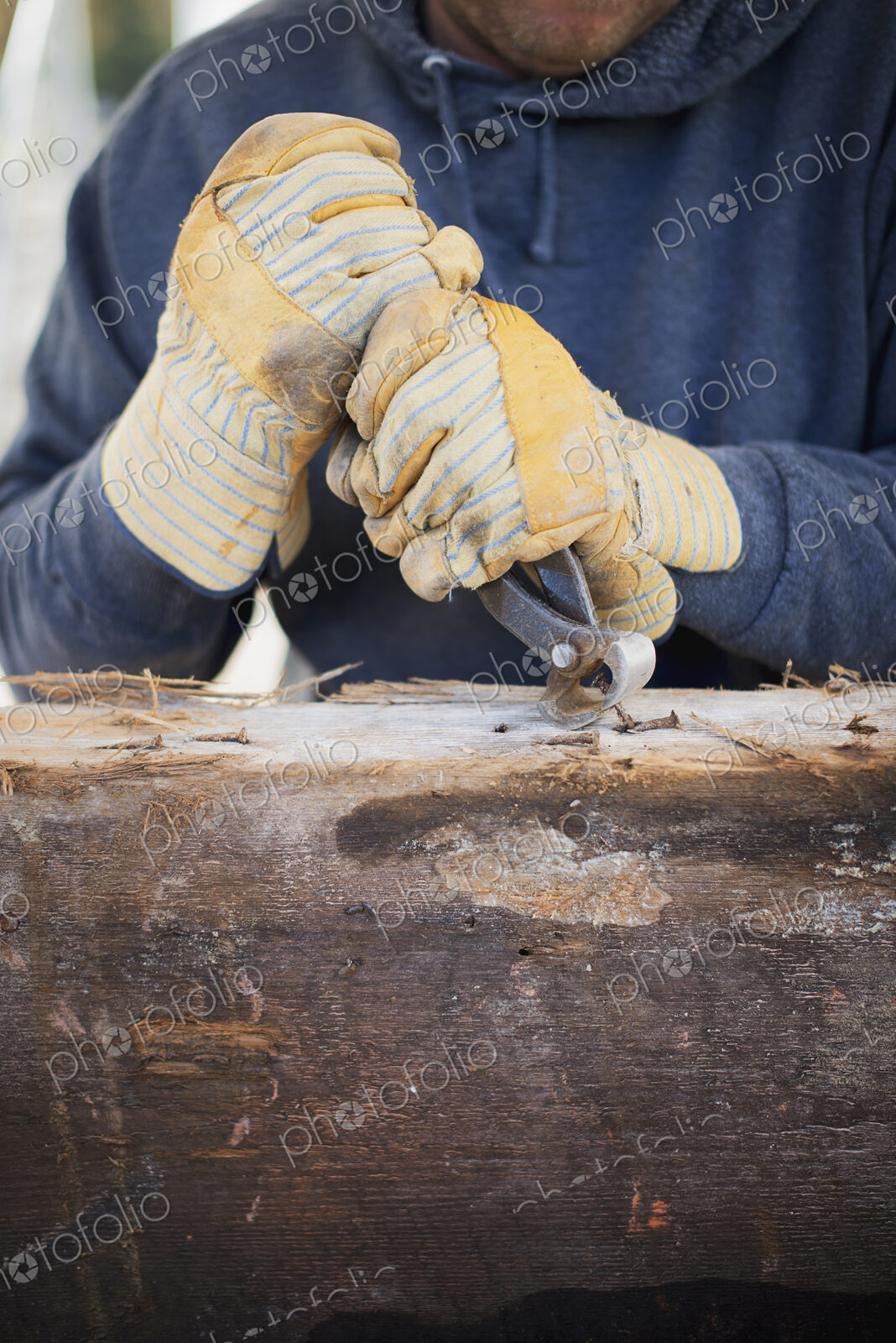A reclaimed lumber workshop. A man preparing the timber by removing all the nails and…
