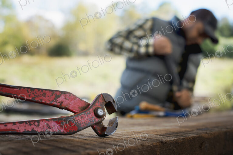 A reclaimed lumber workshop. A man preparing the timber by removing all the nails and…