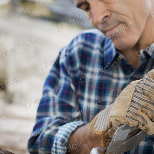 A reclaimed lumber workshop. A man preparing the timber by removing all the nails and… A reclaimed lumber workshop. A man preparing the timber by removing all the nails and…