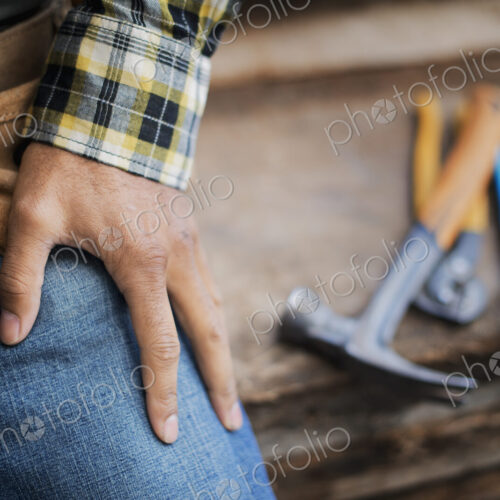 A reclaimed lumber workshop. A person at a workbench, and tools, grippers and pliers… A reclaimed lumber workshop. A person at a workbench, and tools, grippers and pliers…