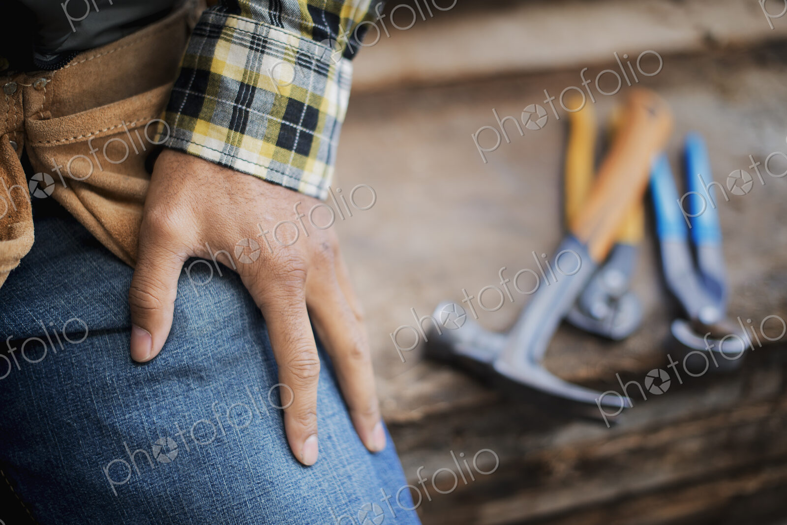 A reclaimed lumber workshop. A person at a workbench, and tools, grippers and pliers…