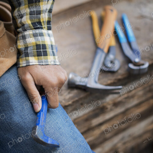A reclaimed lumber workshop. A person at a workbench, and tools, grippers and pliers… A reclaimed lumber workshop. A person at a workbench, and tools, grippers and pliers…