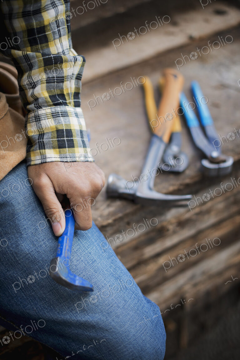 A reclaimed lumber workshop. A person at a workbench, and tools, grippers and pliers…