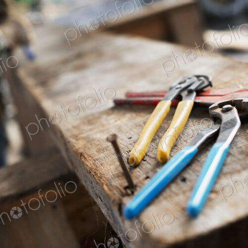 A reclaimed lumber workshop. A person at a workbench, and tools, grippers and pliers… A reclaimed lumber workshop. A person at a workbench, and tools, grippers and pliers…