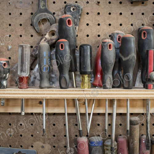 A reclaimed lumber workshop. A tool board, with slots for screwdrivers and handheld… A reclaimed lumber workshop. A tool board, with slots for screwdrivers and handheld…