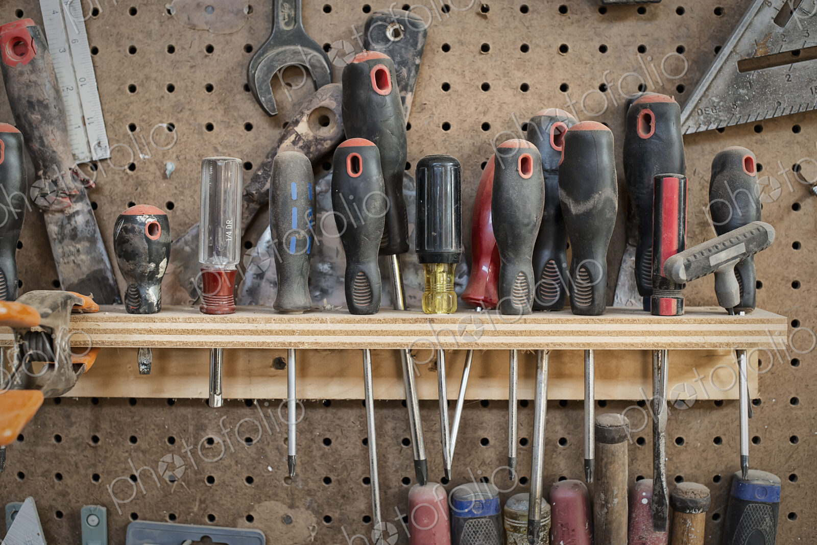 A reclaimed lumber workshop. A tool board, with slots for screwdrivers and handheld…