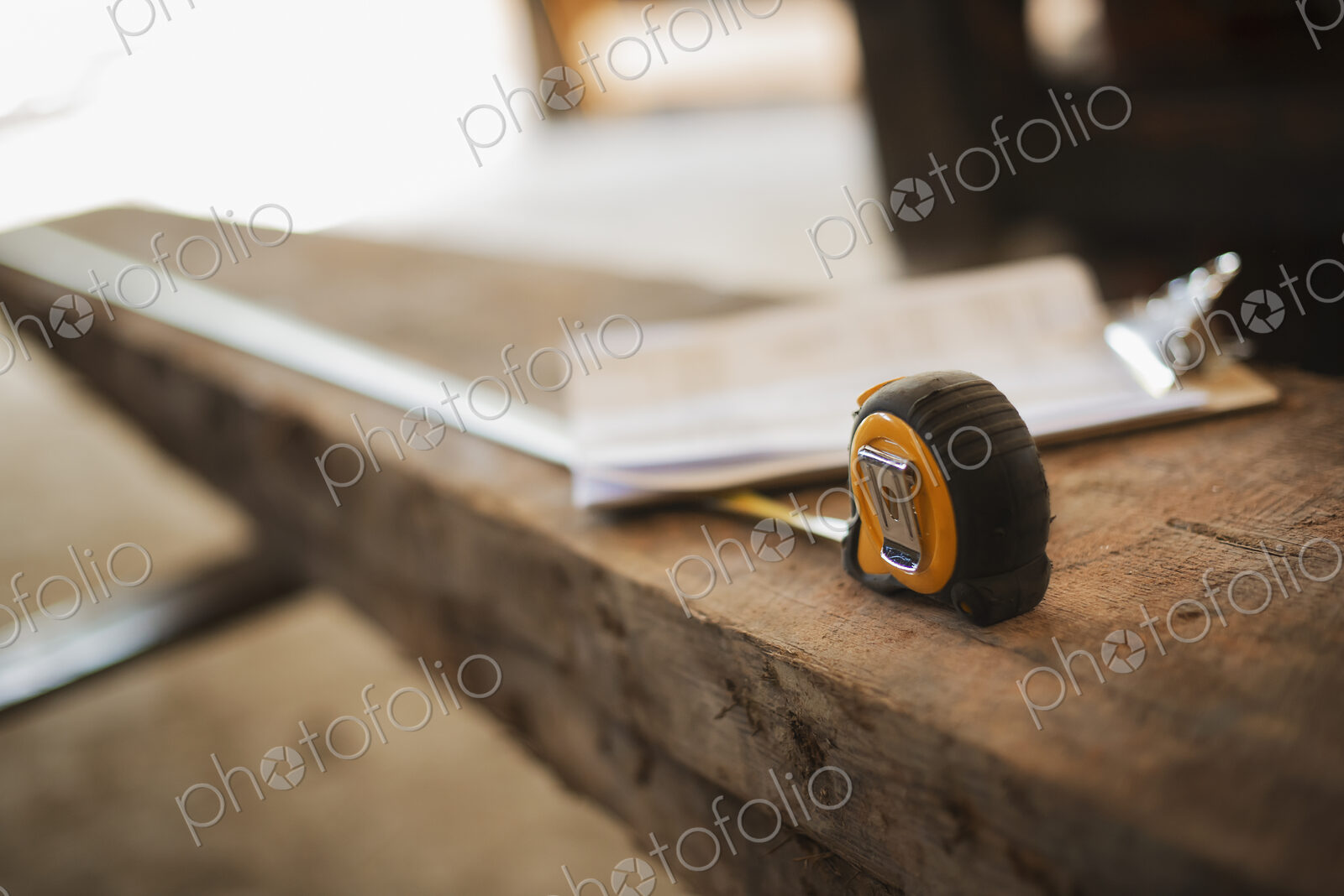 A reclaimed timber yard. Recycled plank of wood, measuring tape and a clipboard with…