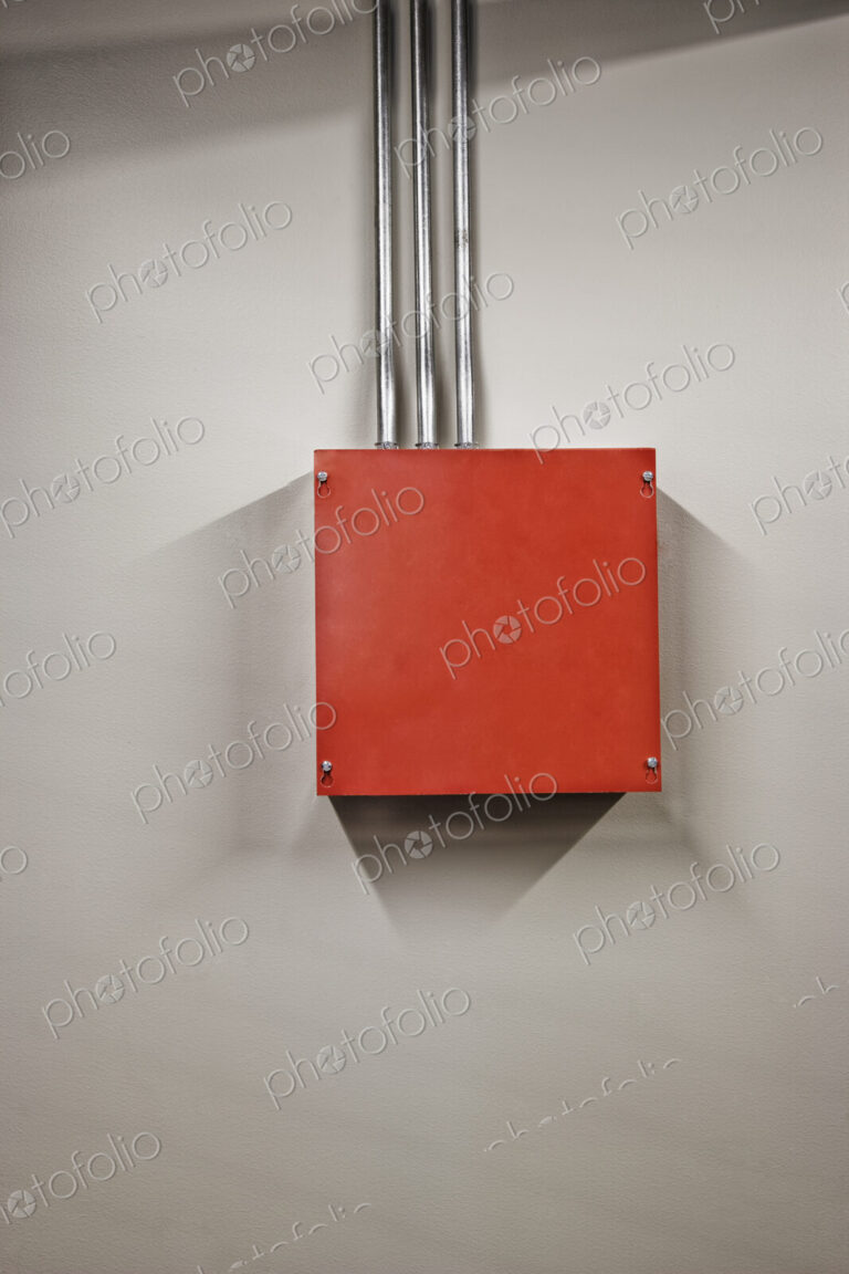 A red metal power junction box in a computer server farm.